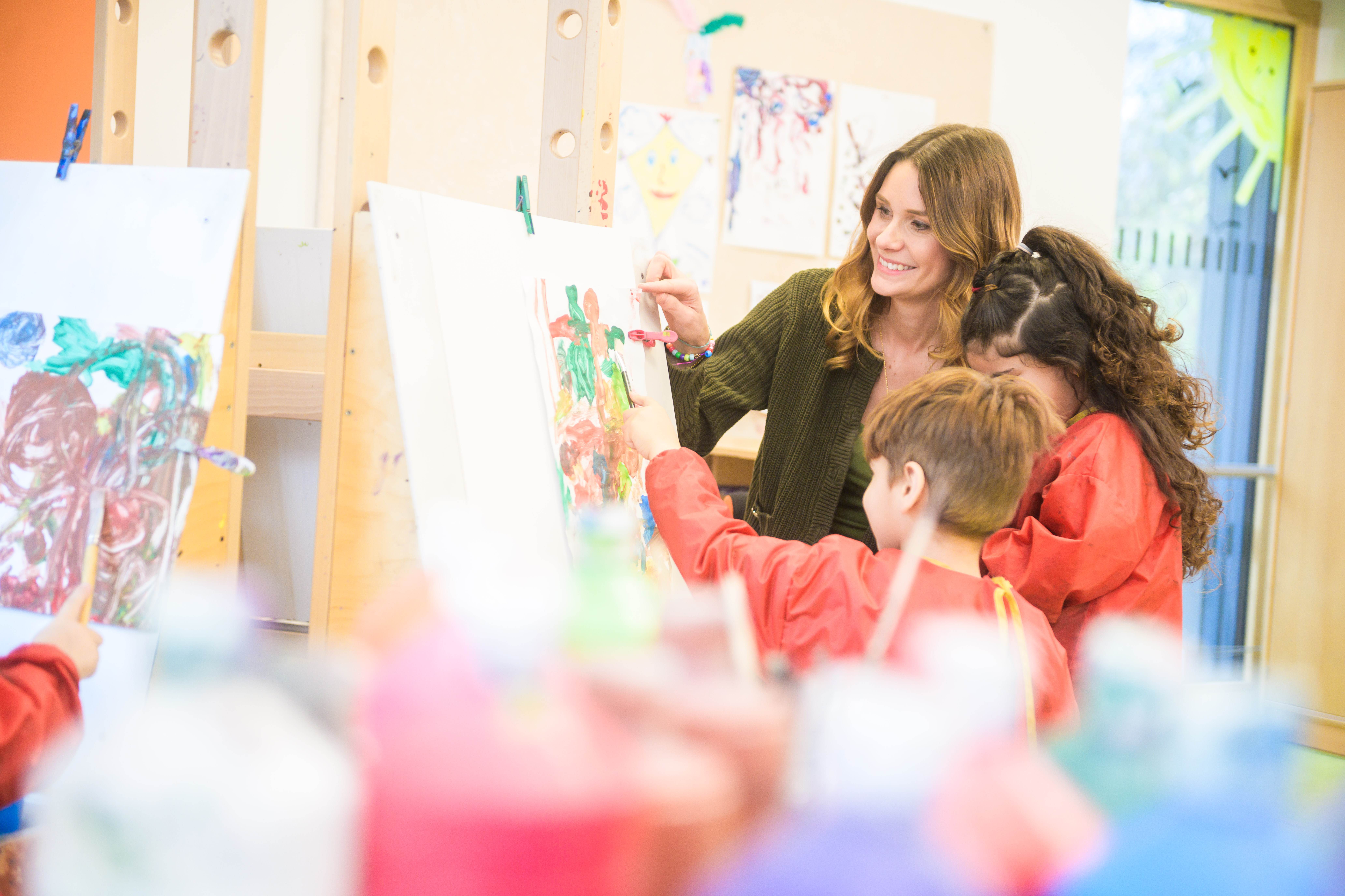 Erzieherin malt gemeinsam mit Kindern